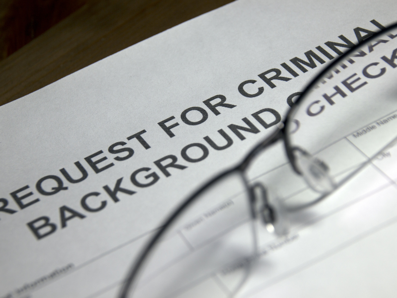 criminal background check paper with glasses sitting on top